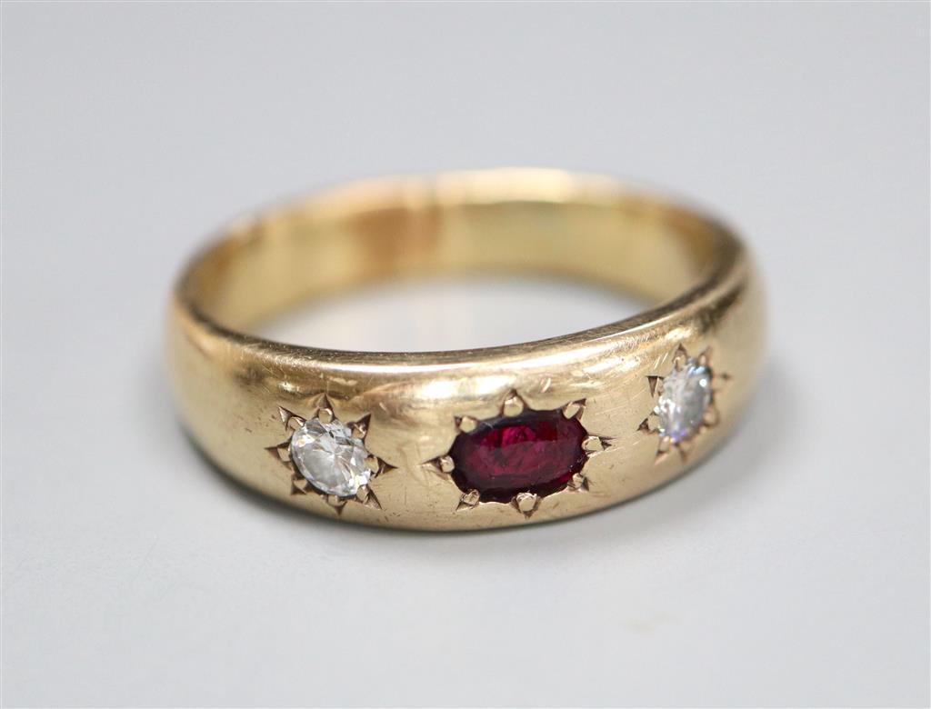 A yellow metal and gypsy set ruby and diamond three stone ring, size U/V, gross 8.9 grams.